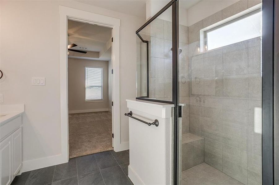 Bathroom with tile patterned floors, vanity, and walk in shower