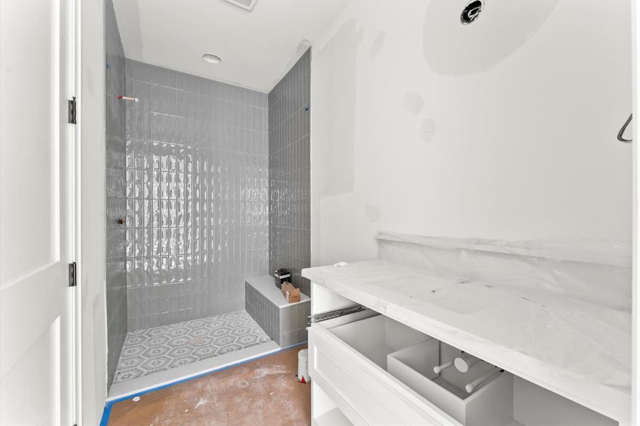 Upstairs bathroom includes quartz countertops, shaker cabinets and large shower with bench.