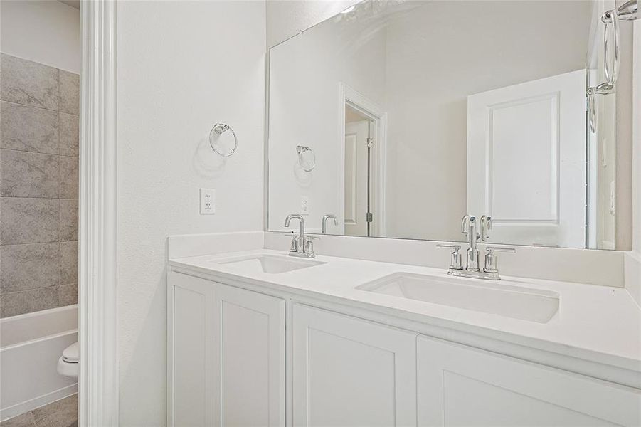 Full bathroom featuring tile patterned floors, vanity, tiled shower / bath combo, and toilet