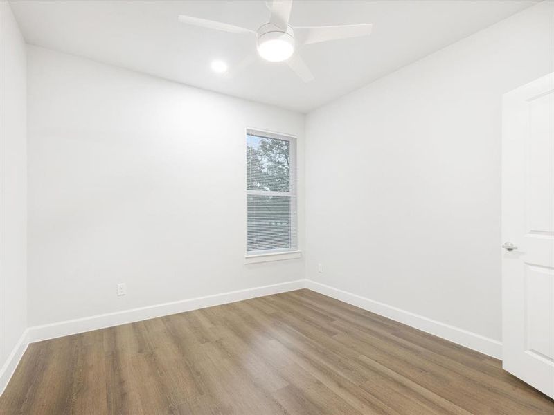 Empty room featuring wood finished floors and a ceiling fan