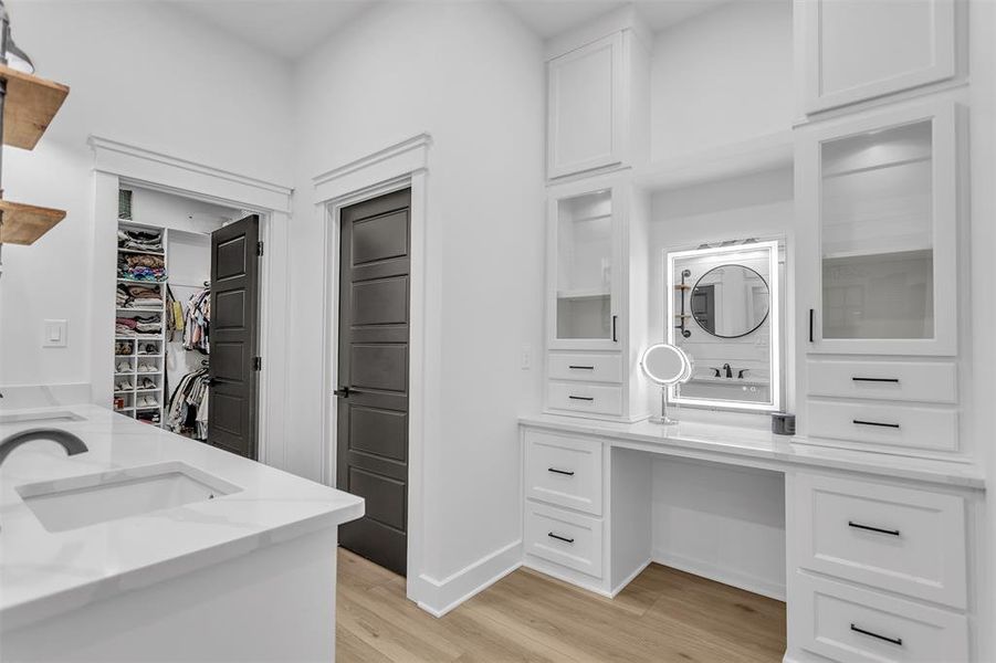Primary Bathroom featuring custom built in vanity accented by glass doors. Primary Bathroom featuring custom built in vanity accented by glass doors.