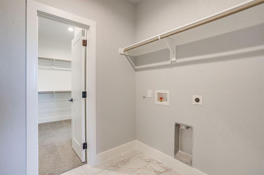 Laundry room featuring light marble finish floors, hookup for a washing machine, electric dryer hookup, and gas dryer hookup