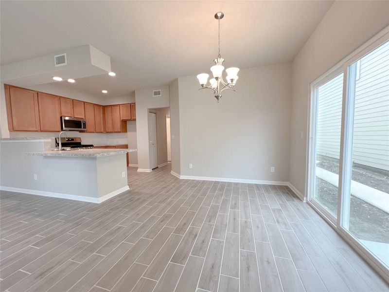 An open floor plan with sleek tile flooring connects the kitchen and dining area. An open floor plan with sleek tile flooring connects the kitchen and dining area.