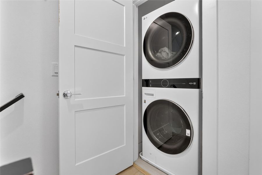 A well-appointed laundry area offers practical convenience with stacked appliances.