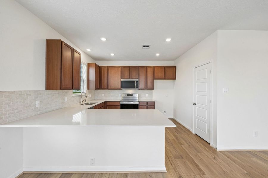 This spacious kitchen has it all—ample storage, generous counter space, and a layout that truly makes it the heart of the home.
