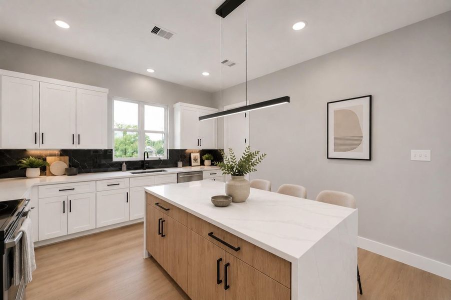 Designer kitchen featuring sleek quartz countertops, custom cabinetry, modern black accents, & a spacious waterfall island perfect for entertaining.