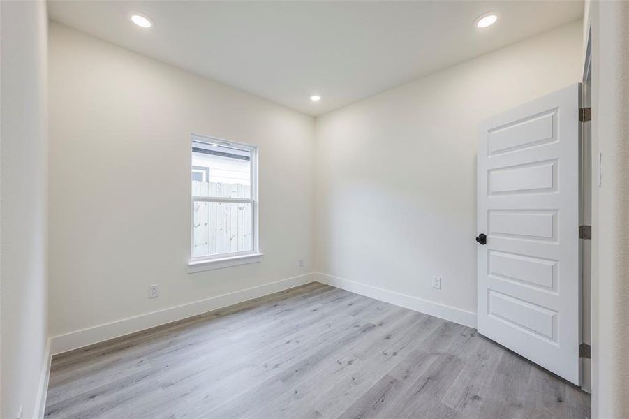 Empty room featuring light wood finished floors and recessed lighting