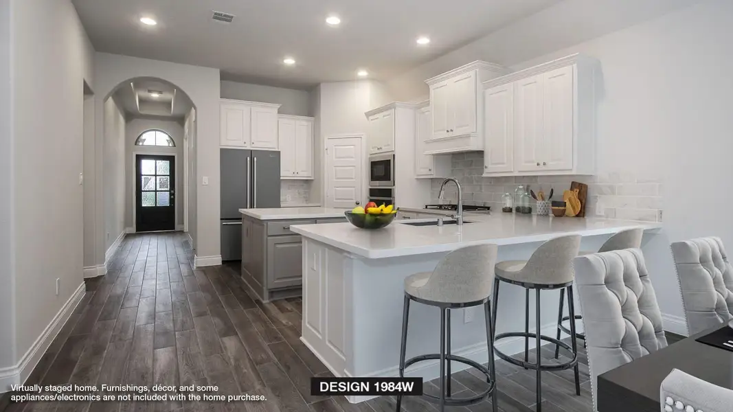Kitchen featuring arched walkways, stainless steel appliances, a sink, visible vents, and a peninsula Kitchen featuring arched walkways, stainless steel appliances, a sink, visible vents, and a peninsula
