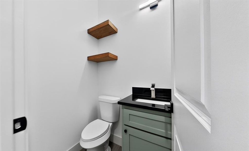 Half bathroom with vanity and toilet