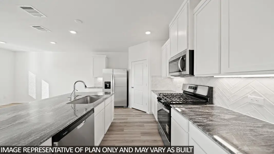 Kitchen featuring stone countertops, stainless steel appliances, white cabinetry, wood-finish flooring, and a herringbone tile backsplash