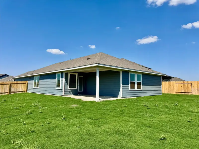 Back of house with a fenced backyard and a patio