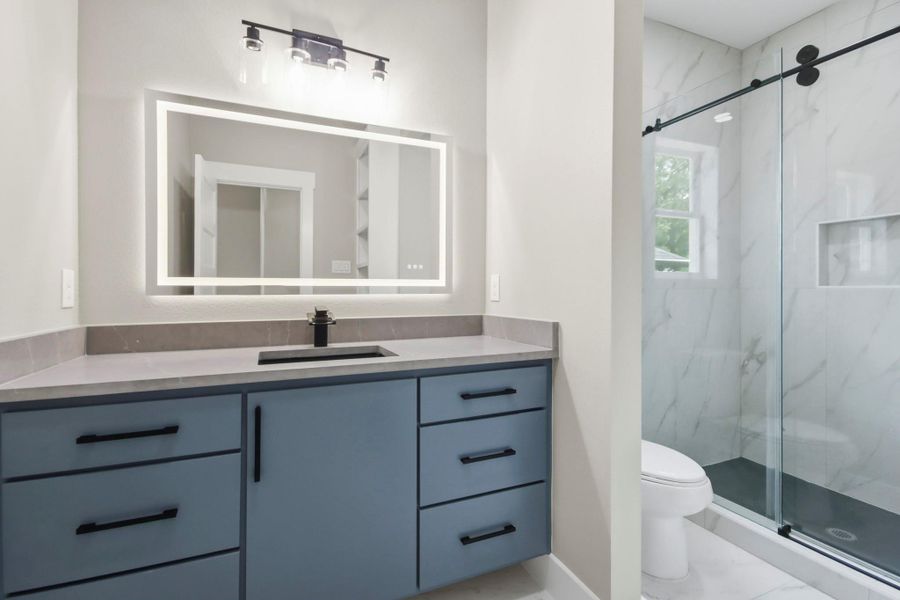 Guests will love the contemporary vanity offering ample storage, paired with designer hardware and dual overhead lighting, an illuminated smart-mirror, and a beautiful walk-in tile shower enclosed by a premium rolling glass door system. Guests will love the contemporary vanity offering ample storage, paired with designer hardware and dual overhead lighting, an illuminated smart-mirror, and a beautiful walk-in tile shower enclosed by a premium rolling glass door system.