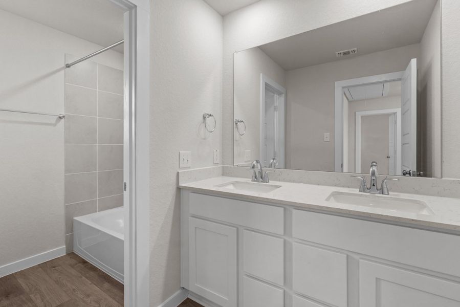 A bathroom with a tub sink and mirror. A bathroom with a tub sink and mirror.