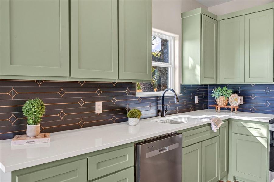 Kitchen featuring green cabinets, stainless steel dishwasher, decorative backsplash, and light stone counters Kitchen featuring green cabinets, stainless steel dishwasher, decorative backsplash, and light stone counters