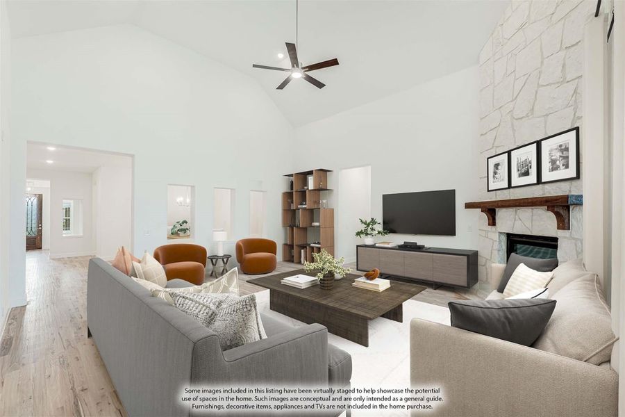 Living room with vaulted ceiling, stone fireplace, ceiling fan, and hardwood floors