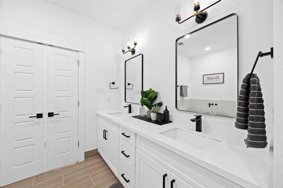 A well-appointed primary bathroom features a spacious layout with elegant finishes. A double-sink vanity provides ample counter space and storage, complemented by stylish fixtures and mirrors that reflect the room’s bright, airy feel. A well-appointed primary bathroom features a spacious layout with elegant finishes. A double-sink vanity provides ample counter space and storage, complemented by stylish fixtures and mirrors that reflect the room’s bright, airy feel.