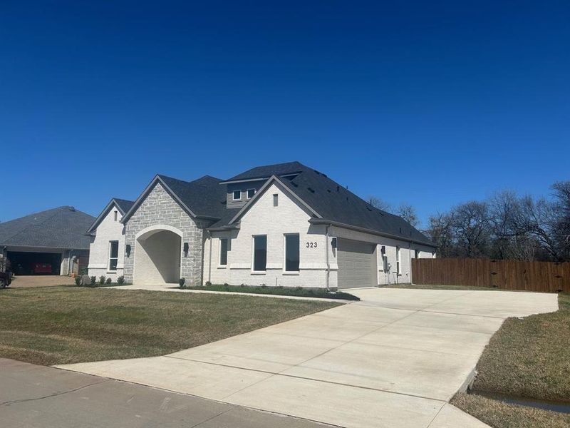 Front elevation showing side-entry garage and wide driveway