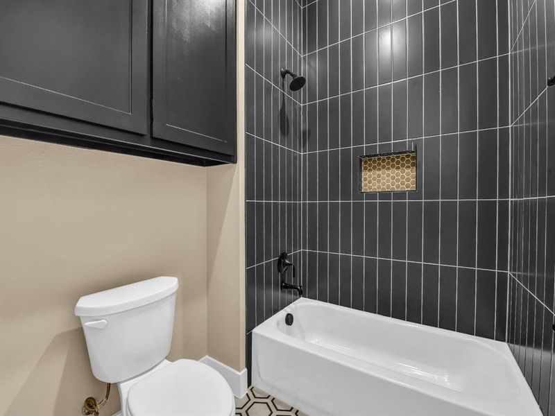 Bathroom with toilet and tiled shower / bath