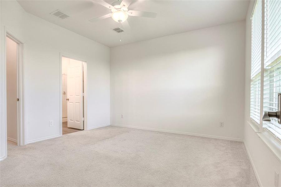 Unfurnished bedroom featuring light colored carpet and a ceiling fan Unfurnished bedroom featuring light colored carpet and a ceiling fan