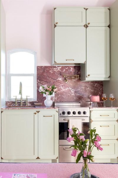 The pink marble countertops and soft sage green creates a playfu but refine take on barbie's dream house.