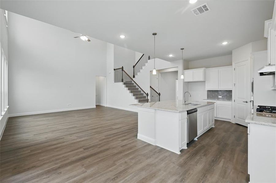 Kitchen with visible vents, dark wood-type flooring, a sink, open floor plan, and exhaust hood