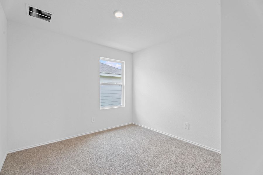 Carpeted empty room with visible vents and baseboards Carpeted empty room with visible vents and baseboards