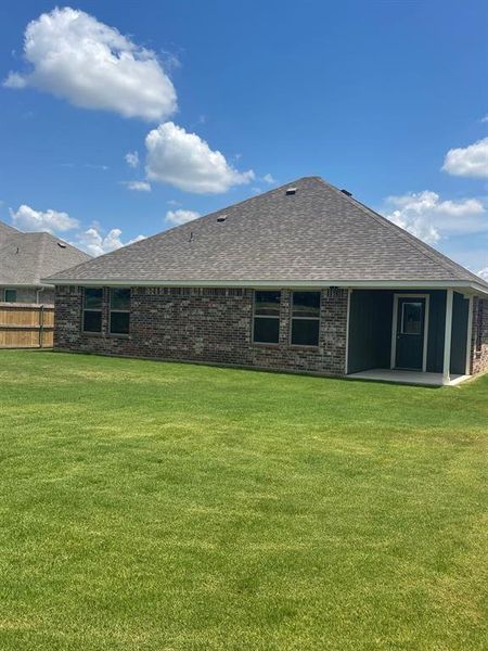 Back of property with a yard and a patio