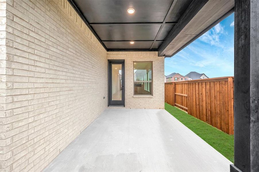 Covered patio featuring a concrete slab and overhead lighting