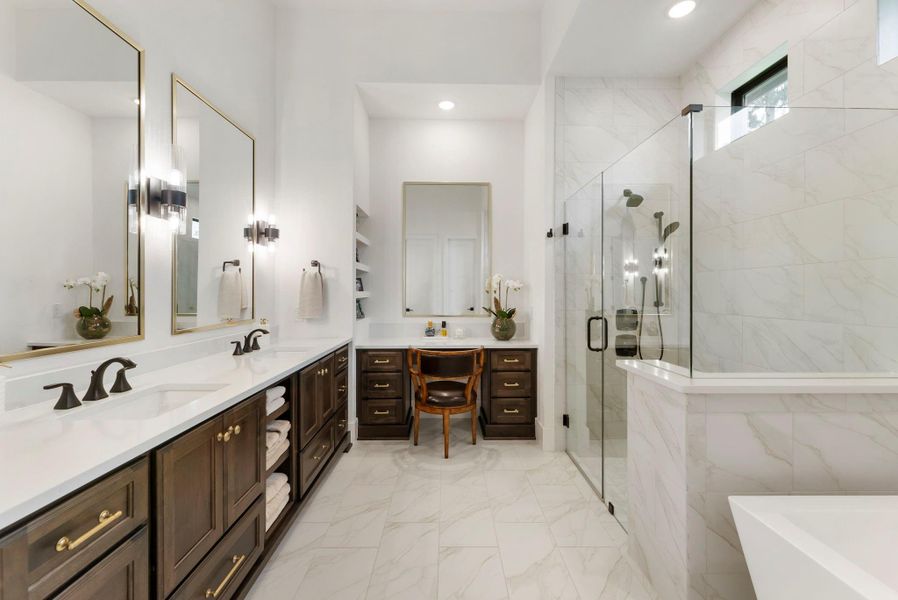 The primary bath offers dual vanities, upgraded cabinetry, added drawers, and a refined finish palette. A dedicated vanity function adds convenience to the daily routine.
