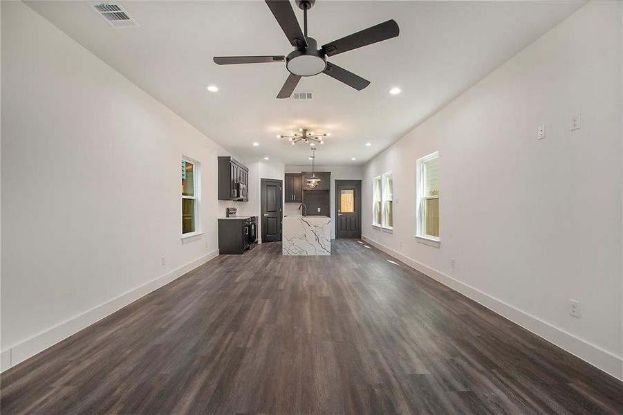 Unfurnished living room featuring dark hardwood / wood-style flooring and ceiling fan