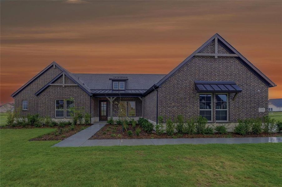 Brick exterior featuring gabled rooflines, dark framed windows, a metal awning, and a prominent front door with side lights Brick exterior featuring gabled rooflines, dark framed windows, a metal awning, and a prominent front door with side lights