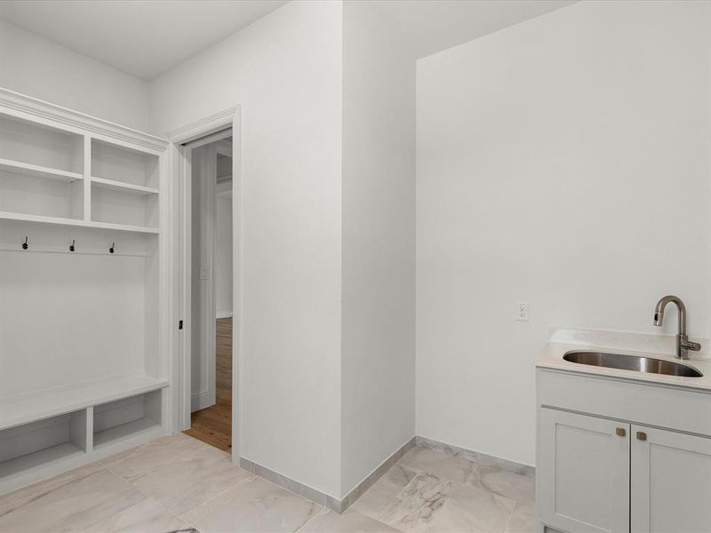 Laundry area with a sink and light marble finish flooring