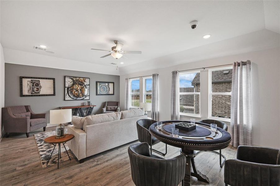 Living room featuring lofted ceiling, ceiling fan, and dark hardwood / wood-style flooring