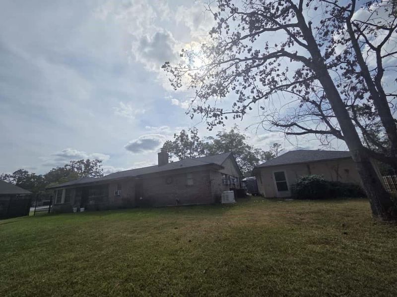 Back of house featuring a lawn and a chimney Back of house featuring a lawn and a chimney
