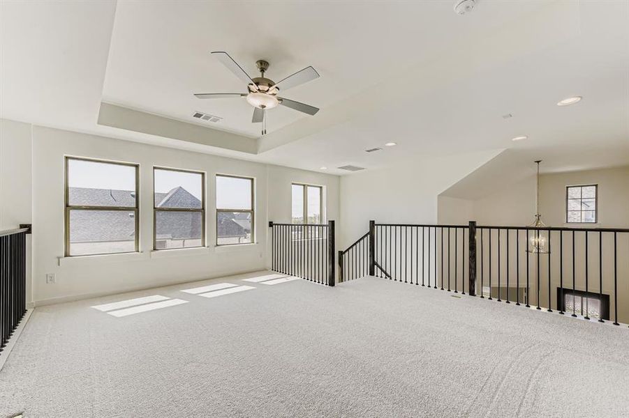 Carpeted spare room with a ceiling fan, a tray ceiling, and recessed lighting Carpeted spare room with a ceiling fan, a tray ceiling, and recessed lighting