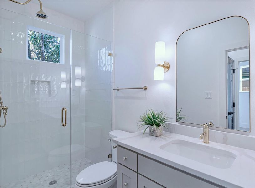 Bathroom featuring toilet, a stall shower, and vanity