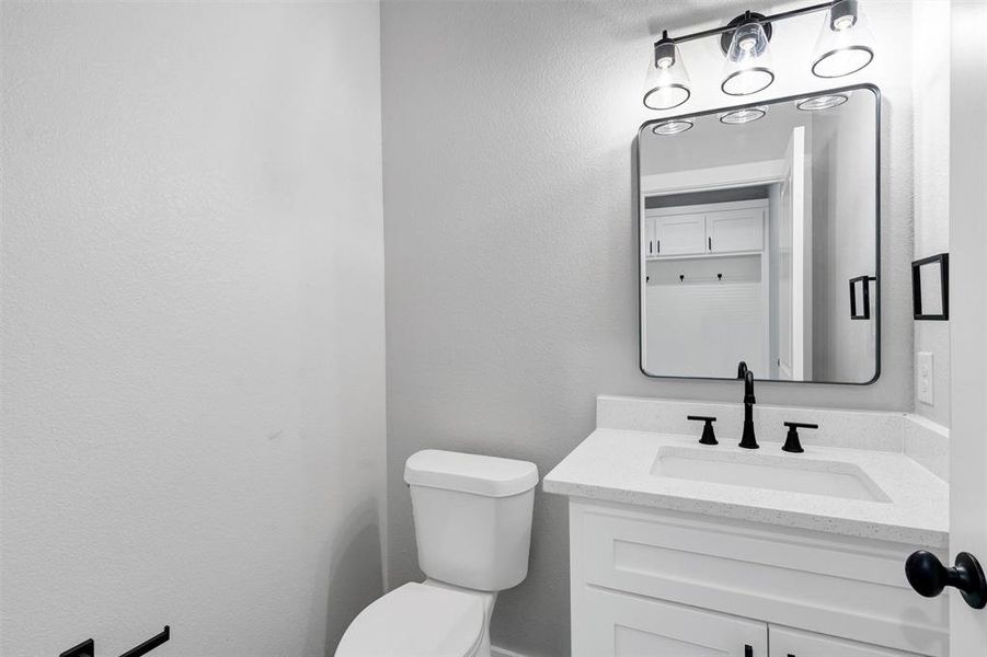 Half bathroom featuring toilet and vanity
