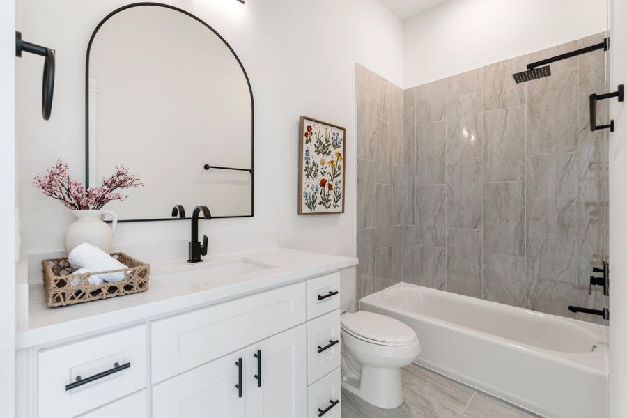 Secondary bedroom's ensuite bathroom with a shower/tub combo.