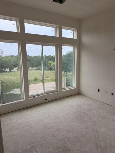 Expansive window wall with transom windows and a sliding glass door, providing abundant natural light