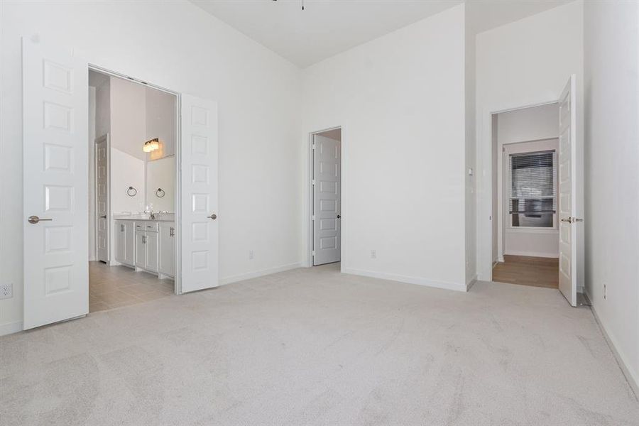 Unfurnished bedroom with light carpet and connected bathroom Unfurnished bedroom with light carpet and connected bathroom