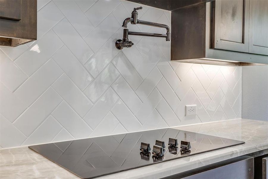 Kitchen featuring light stone countertops, dark brown cabinets, and decorative backsplash