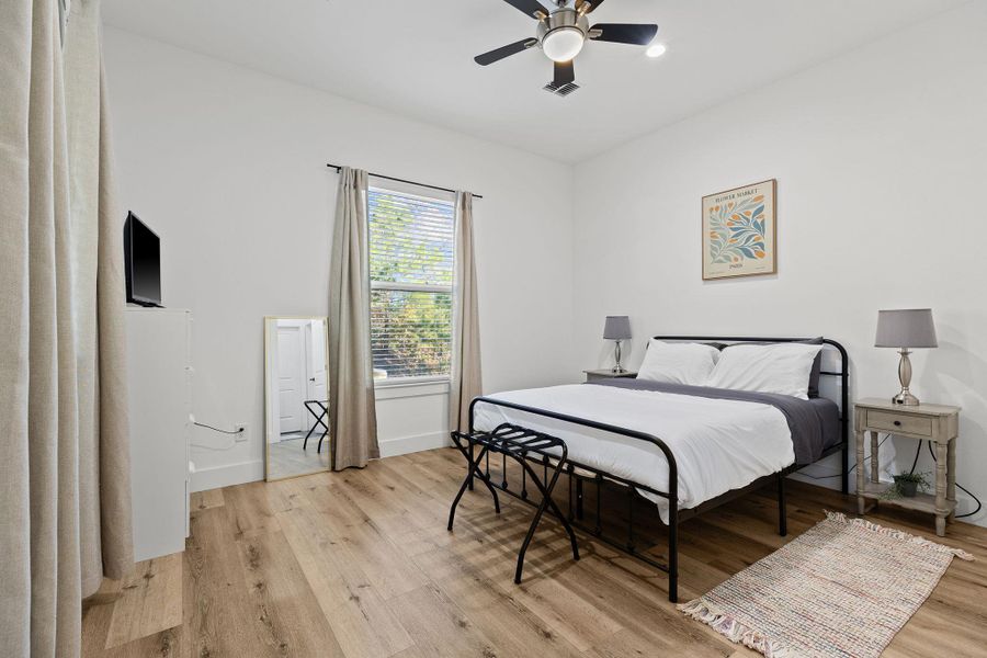 Bedroom with a ceiling fan and light wood-style flooring