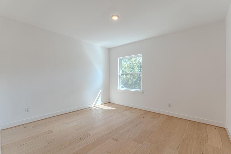 This photo showcases a bright, unfurnished room with light wood flooring and white walls. A single window allows natural light to fill the space, creating a clean and inviting atmosphere.