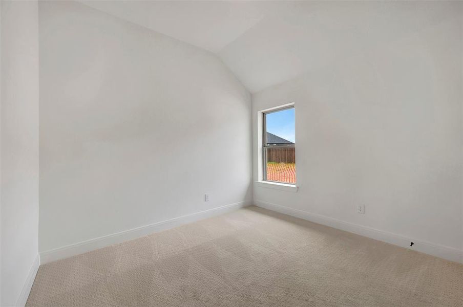 Room featuring a single-pane window, vaulted ceiling, neutral wall color, and carpeted flooring