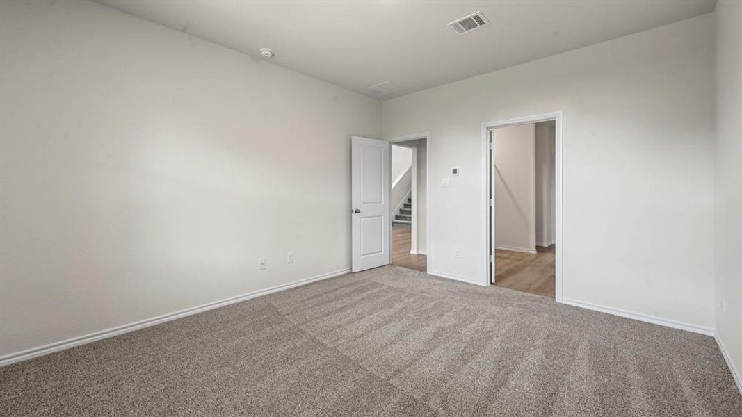 Neutral-toned wall-to-wall carpeting and bright white walls create an inviting interior space