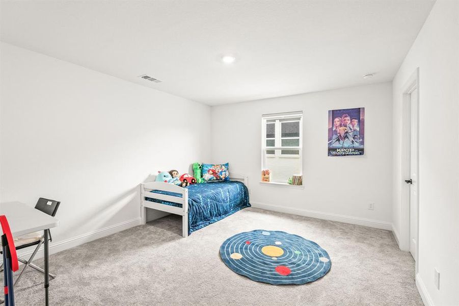Bedroom with light carpet and baseboards