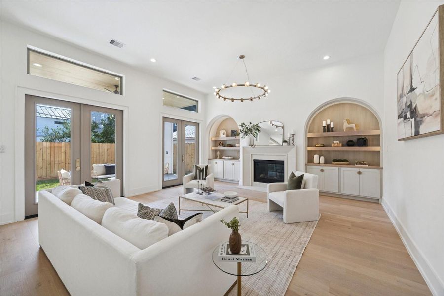 Two sets of French doors flood the room with natural light while providing seamless access to the covered porch and backyard.