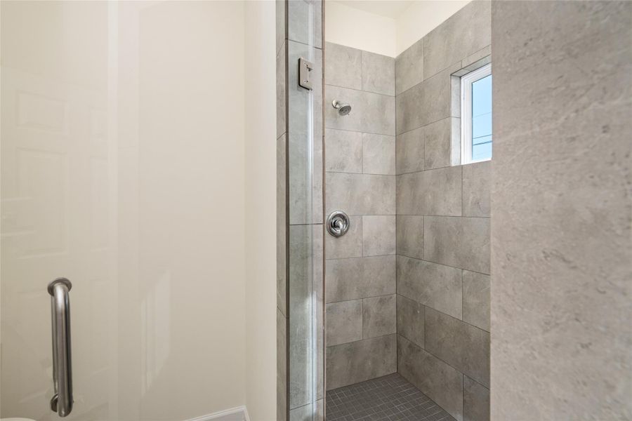 Contemporary walk-in shower with designer tile and glass enclosure.
