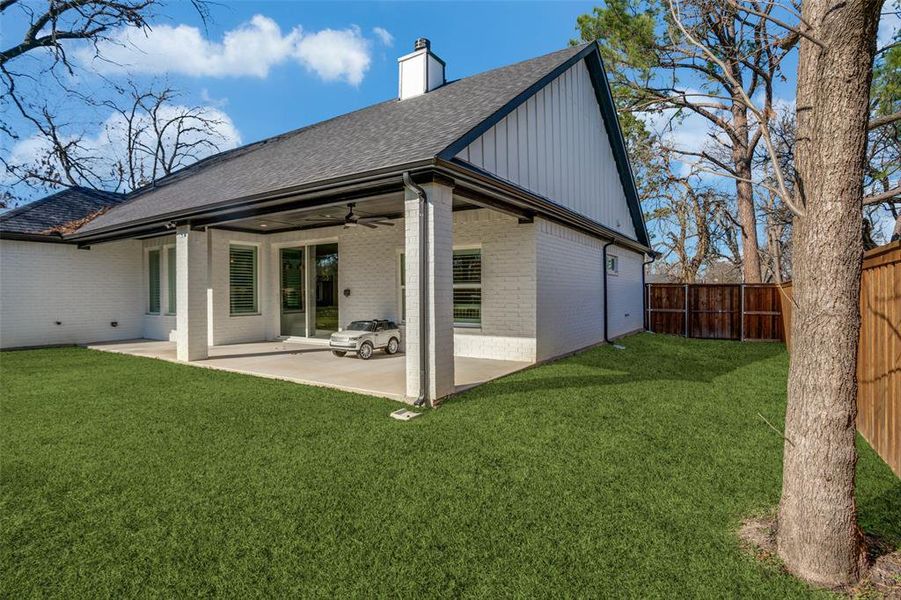 Back of property with a yard, a patio, and ceiling fan