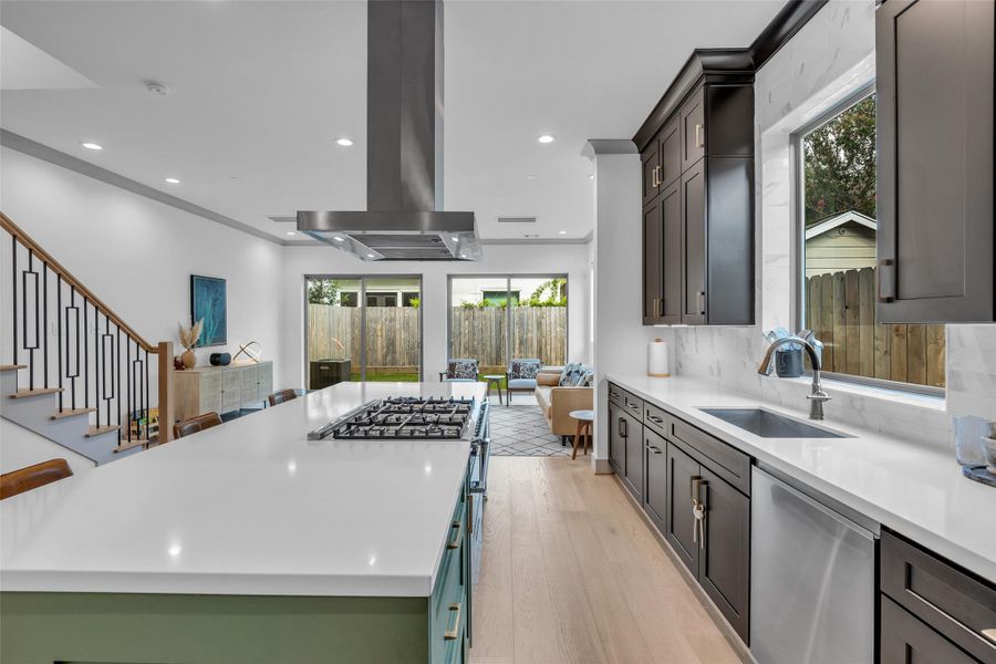It features a large center island with a built-in gas range, providing plenty of workspace for meal preparation and gathering with family and friends.